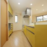 １階キッチン　鮮やかなイエローを基調とした明るいキッチン　すぐ後ろ側にパントリー（食品庫）があります。 (キッチン)